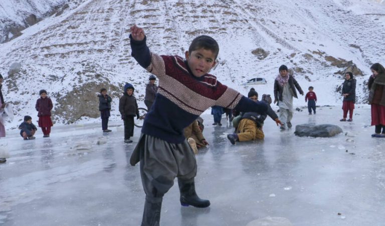 Afghan children play with snow in Kakan village of Argo district, Badakhshan province on January 20, 2023. (Photo by OMER ABRAR / AFP)