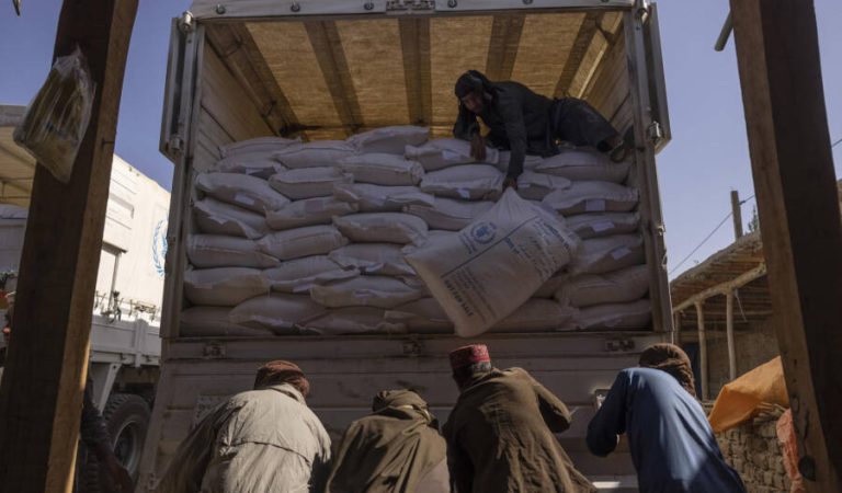 FILE — Sacks of flour from a World Food Program convoy are unloaded in Afghanistan on Oct. 27, 2021. The Biden administration on Wednesday, Dec. 22, 2021, took steps to ease the pressure that sanctions on the Taliban are having on Afghanistan as the combination of the pandemic, a severe drought, the loss of foreign aid and frozen currency reserves have left the country’s fragile economy on the brink of collapse. (Victor J. Blue/The New York Times)