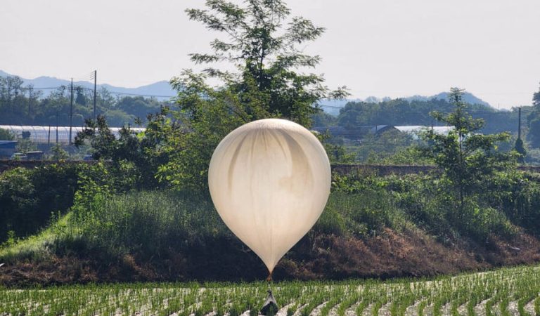 FILE PHOTO: A balloon believed to have been sent by North Korea, carrying various objects including what appeared to be trash and excrement, is seen over a rice field at Cheorwon, South Korea, May 29, 2024. Yonhap via REUTERS/File photo