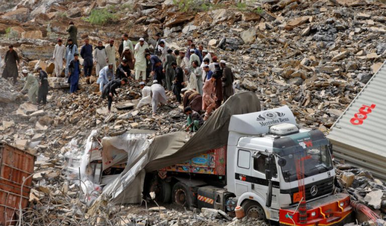 People search for survivors next to a damaged supply vehicle after a landslide close to the Torkham border, Pakistan, April 18, 2023. REUTERS/Fayaz Aziz
