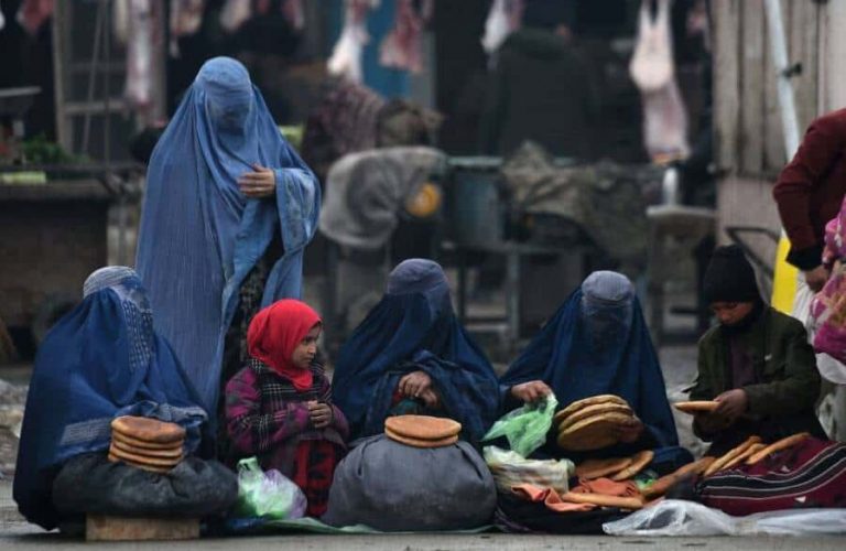 In this photograph taken on January 31, 2019, Afghan women wearing burqas sell bread on a street in Mazar-i-Sharif. (Photo by FARSHAD USYAN / AFP)        (Photo credit should read FARSHAD USYAN/AFP via Getty Images)