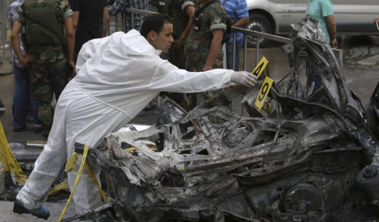 A Lebanese army investigator inspects a destroyed car at the site of a car bomb explosion in southern Beirut, Lebanon, Friday, Aug. 16, 2013. A powerful car bomb tore through a bustling south Beirut neighborhood that is a stronghold of Hezbollah on Thursday, killing at least 18 and trapping dozens of others in an inferno of burning cars and buildings in the bloodiest attack yet on Lebanese civilians linked to Syria's civil war. (AP Photo/Hussein Malla)