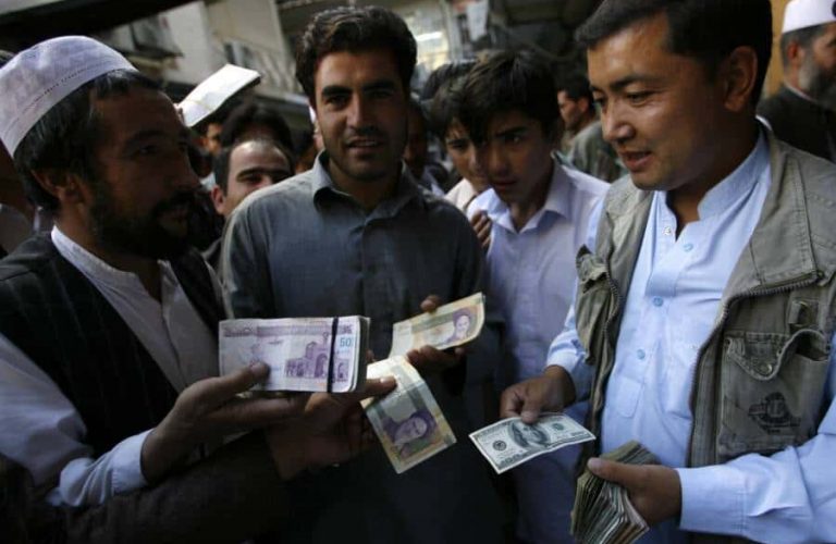 Afghan money changers gather to deal with foreign currency at a money change market in Herat October 4, 2012. Afghanistan has imposed a cap on U.S. dollar flows across the border with Iran amid clashes there between Iranian police and protesters prompted by a collapse in the rial currency, Afghan police said on Thursday. REUTERS/Mohammad Shoib (AFGHANISTAN - Tags: SOCIETY BUSINESS)