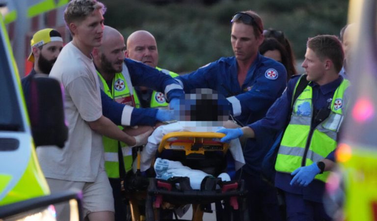 Emergency workers transport a person on a stretcher after a reported shooting at Bondi Beach, in Sydney, Sunday, Dec. 14, 2025. (AP Photo/Mark Baker)