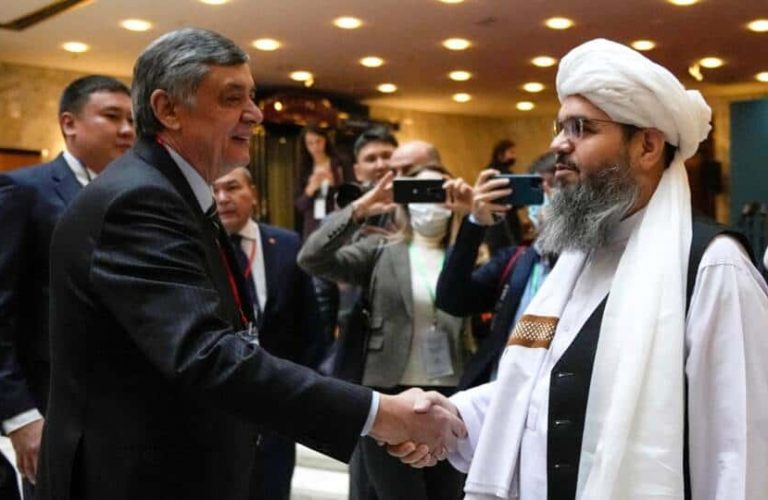Russian presidential envoy to Afghanistan Zamir Kabulov (L) shakes hands with a member of the Taliban delegation Mawlawi Shahabuddin Dilawar prior to an international conference on Afghanistan in Moscow on October 20, 2021. (Photo by Alexander Zemlianichenko / POOL / AFP)