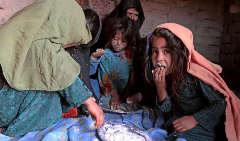 HERAT, AFGHANISTAN - JANUARY 11: Afghan children eat flour as the poverty rate has increased in Herat, Afghanistan on January 11, 2022. Afghan father Mir Hamza Musazey, Afghan mother Alembibi Musazey and their children have been forced to eat only dry flour for days. Father Mir Hamza Musazey said that he has sold 2 of his daughters so far due to poverty, and that he wants to sell 4 more daughters. Children continue to go to the tent schools opened by UNICEF, where their homes are located, and try to learn to read and write with the books provided there. (Photo by Bilal Guler/Anadolu Agency via Getty Images)