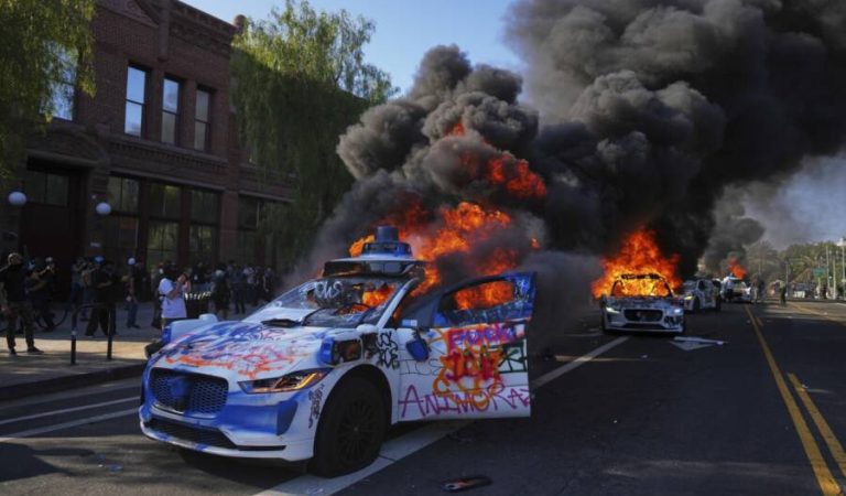 Multiple Waymo taxis burn near the Metropolitan Detention Center of downtown Los Angeles, Sunday, June 8, 2025, following last night's immigration raid protest. (AP Photo/Eric Thayer)
