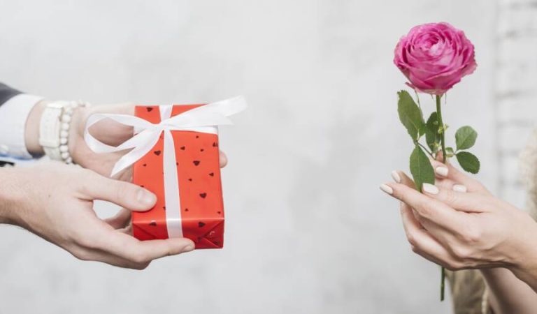 crop-man-giving-gift-woman-with-rose