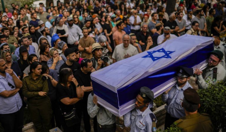 FILE - Israeli soldiers carry the flag-covered coffin of Shilo Rauchberger at the Mount Herzl cemetery in Jerusalem,  Thursday, Oct. 12, 2023. In Israel on Saturday, rabbis worked around the clock at Shura military base in Israel to identify and count the dead civilians and soldiers gunned down in the Hamas attack last week. Israel's military rabbinate is working on Shabbat for the first time since 2005. Some of the bodies have been brought to Mount Herzl, Israel's national cemetery in Jerusalem. (AP Photo/Francisco Seco, File)