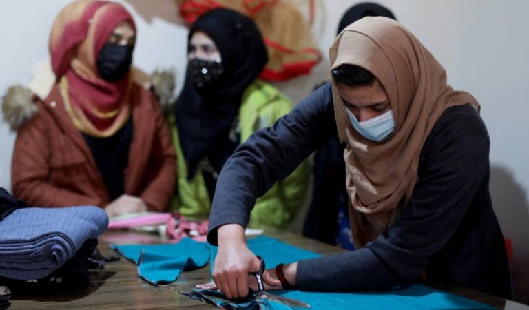 An Afghan woman cuts a fabric at a sewing workshop in Kabul, Afghanistan January 15, 2022. REUTERS/Ali Khara