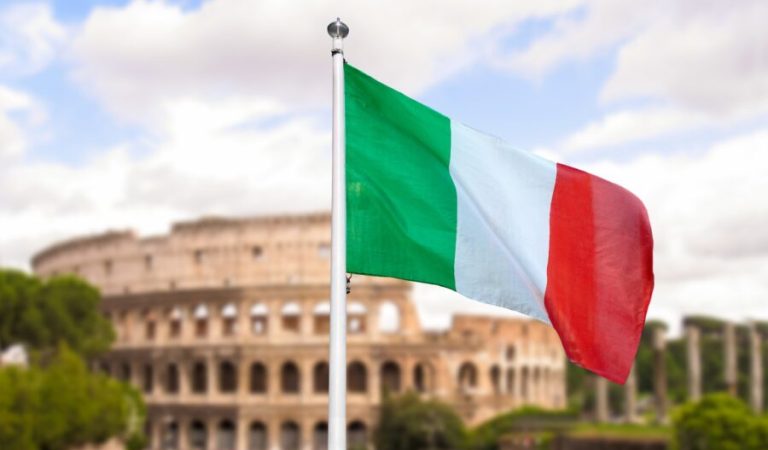 National flag of Italy waving into blue sky with colosseum background