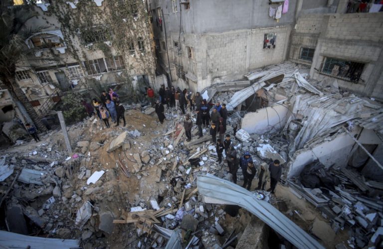 A large group of Palestinians gathers at the site of the destroyed house in Al-Maghazi refugee camp, central Gaza Strip, on December 19, 2024. The Israeli airstrike targeted the home of the Darwish family, leaving devastation in its wake. (Photo by Saeed Jaras / Middle East Images / Middle East Images via AFP)