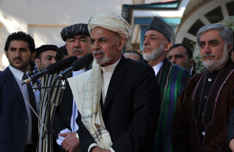 Afghan President Ashraf Ghani (C) speaks to the juornalists as Afghan Chief Executive Officer, Abdullah Abdullah (R) and former Afghan President Hamid Karzai (2R) look on after morning Eid al-Adha prayers at a mosque in the Presidential Palace in Kabul on October 4, 2014. Muslims around the world celebrate the Eid al-Adha, also called the Feast of the Sacrifice, to commemorate Prophet Abraham's readiness to sacrifice his son as an act of obedience to God. AFP PHOTO/Noorullah Shirzada        (Photo credit should read Noorullah Shirzada/AFP/Getty Images)