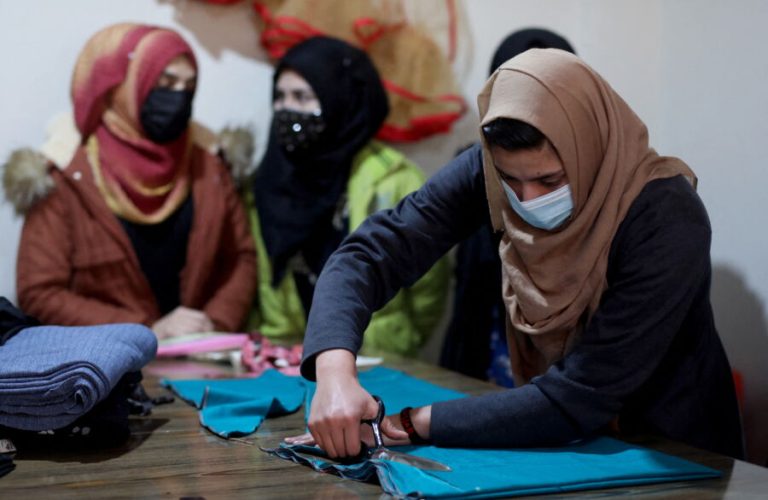 An Afghan woman cuts a fabric at a sewing workshop in Kabul, Afghanistan January 15, 2022. REUTERS/Ali Khara