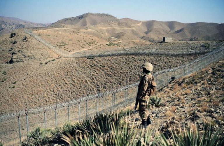 A Pakistani soldier keeps vigil next to a newly fenced border fencing along Afghan border at Kitton Orchard Post in Pakistan's North Waziristan tribal agency on October 18, 2017.The Pakistan military vowed on October 18 a new border fence and hundreds of forts would help curb militancy, as it showcased efforts aimed at sealing the rugged border with Afghanistan long crossed at will by insurgents.   / AFP PHOTO / AAMIR QURESHI