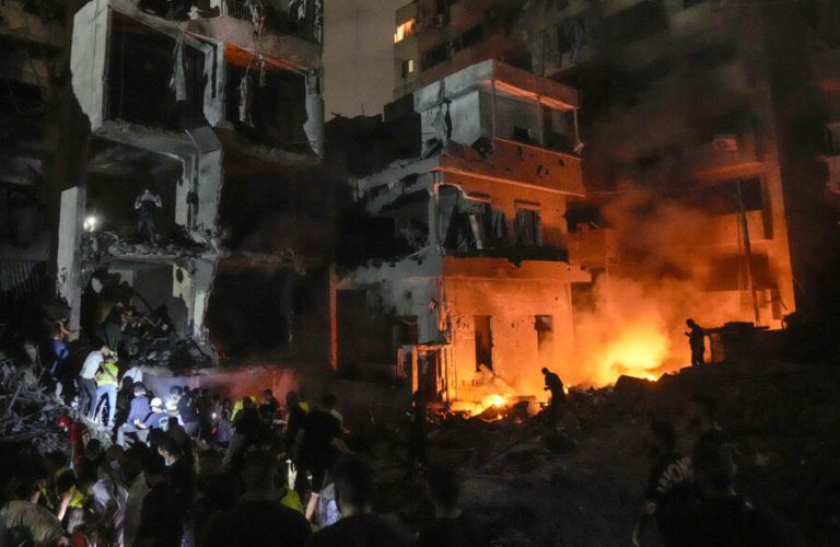 People gather in front of destroyed buildings hit by an Israeli airstrike in central Beirut, Lebanon, Thursday, Oct. 10, 2024. (AP Photo/Bilal Hussein)