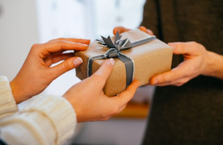 Young,Woman,Gives,A,Gift,In,A,Box