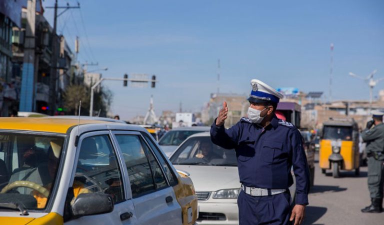 A policeman wearing a mask guides vehicles in Herat province, western Afghanistan, on March 8. Xinhua/Elaha Sahel via Getty Images