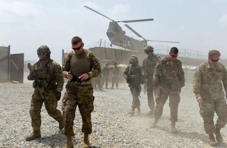 U.S. Army soldiers walk as a NATO helicopter flies overhead at coalition force Forward Operating Base (FOB) Connelly in the Khogyani district in the eastern province of Nangarhar on August 13, 2015.