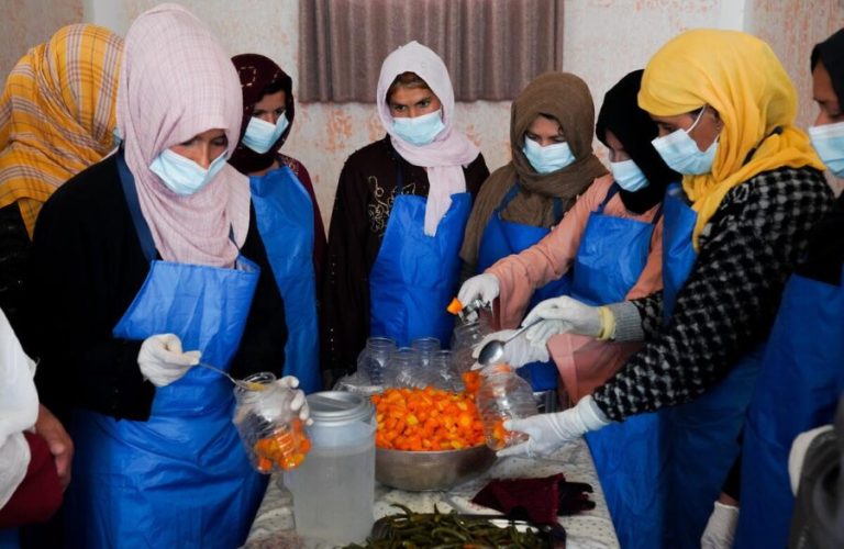 18 March 2025. Parwan province, Afghanistan. Women work together in a Common Interest Group (CIG), filling jars with chopped vegetables to produce pickles.