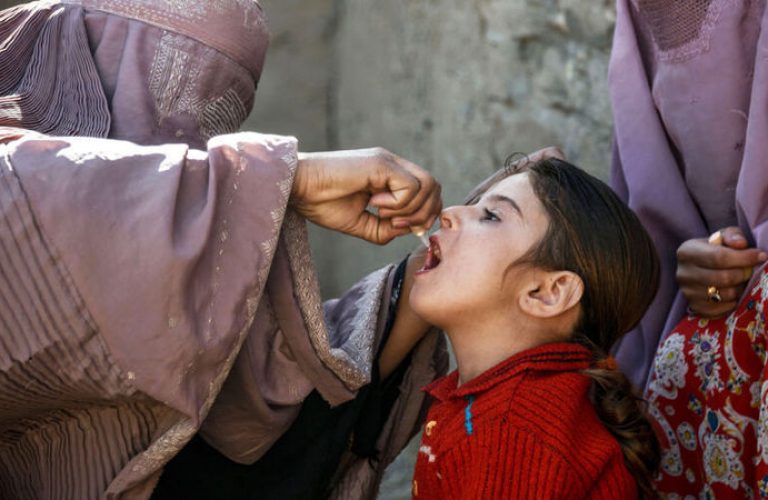 In this photo taken on March 20, 2019, an Afghan health worker administers a polio vaccine to a child in Kandahar province's Arghandab district. - Polio immunisation is compulsory in Afghanistan, but distrust of vaccines is rife, and the programmes are difficult to enforce particularly in rural regions. Militants and religious leaders tell locals that vaccines are a Western conspiracy aiming to sterilise Muslim children, or that such programmes are an elaborate cover for Western or Afghan government spies. (Photo by JAVED TANVEER / AFP) / To go with 'AFGHANISTAN-CONFLICT-VACCINES-POLIO-TALIBAN', FEATURE by Rashid Durrani with Usman Sharifi        (Photo credit should read JAVED TANVEER/AFP via Getty Images)