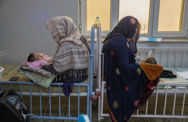 Two mothers carrying their children in the New Natal Ward.