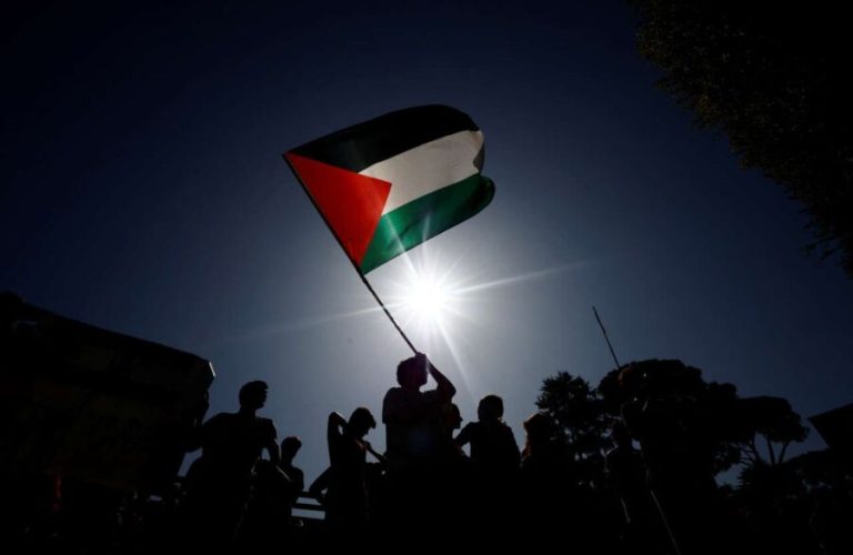 A person holds a Palestinian flag as students demonstrate to express support for the people of Palestine during a protest at La Sapienza University, in Rome, October 10, 2023. REUTERS/Yara Nardi - RC2OP3AKGZQW