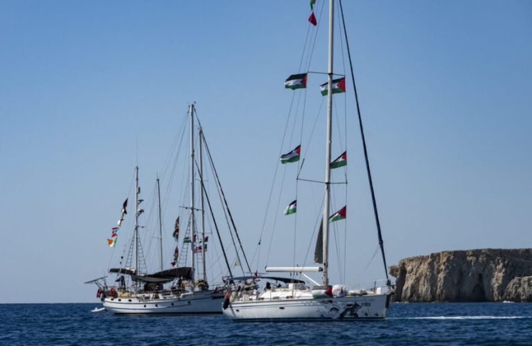 Members of the group of ships of the Global Sumud Flotilla to Gaza are seen moored at the small island of Koufonisi, south of the island of Crete, on September 26, 2025. After a reported attack by drones early on September 25, 2025 morning, Athens has said it will guarantee safe sailing in its waters. The Global Sumud Flotilla, carrying activists including Swedish environmentalist Greta Thunberg, blamed Israel for more than a dozen explosions heard around its vessels off Greece late on September 24, 2025. (Photo by Eleftherios ELIS / AFP)