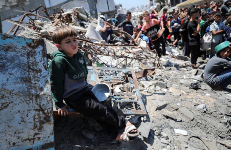 FILE PHOTO: A child sits, as Palestinians wait to receive food cooked by a charity kitchen, in Beit Lahia, northern Gaza Strip, May 8, 2025. REUTERS/Mahmoud Issa/File Photo NO RESALES. NO ARCHIVES.