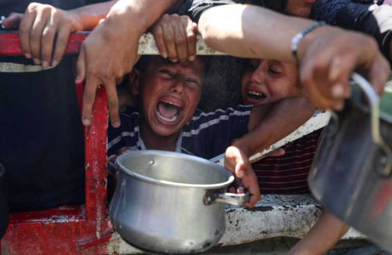 Palestinians wait to receive food from a charity kitchen, amid a hunger crisis, in Gaza City, July 23, 2025. REUTERS/Mahmoud Issa     TPX IMAGES OF THE DAY